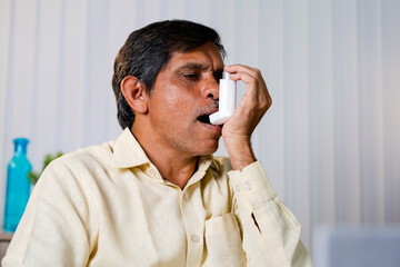 unhealthy Businssman uses asthma inhaler as medication at office - concept of healthcare, medical, work lifestyle and non communicable diseases. - obrazy, fototapety, plakaty