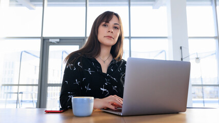 Office in a cafe - a young woman works on a laptop