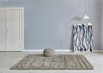Grey stone wall background with white wooden door, lamp carpet and home style, poster decoration room interior.