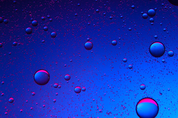 abstract background. drops of oil on water, blue and red. macro