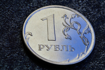 a Russian one ruble coin lies on a dark metal background. close-up