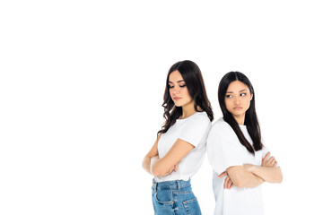 offended interracial women standing back to back with crossed arms isolated on white.