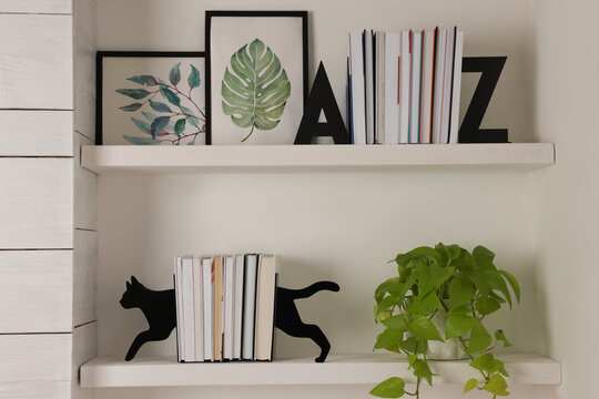 Bookends and other decor on shelves indoors. Interior design