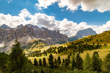 Panorama view of Gardena Pass, Sassolungo, Piz Boe, and Sass dla Luesa, Trentino Alto Adige, Italy. Alpine meadows and Passo Gardena. - obrazy, fototapety, plakaty