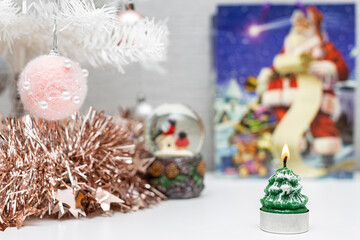 decorative lighted candle is lit on the background of christmas decorations