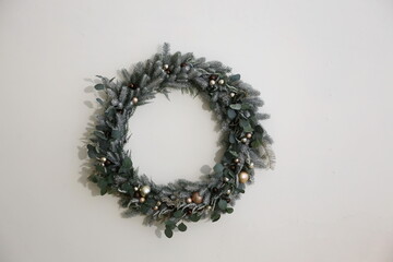 Christmas wreath of pine needles  on a white wall background