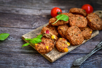 Home made baked chicken and vegetables  meatballs with fresh parsley and organic bio cherry tomatoes on black background