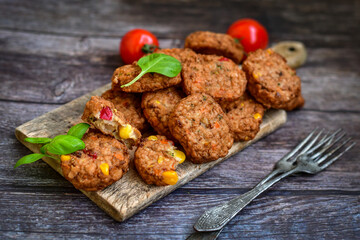 Home made baked chicken and vegetables  meatballs with fresh parsley and organic bio cherry tomatoes on black background