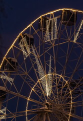 Part of a Ferris wheel decorated with light garlands at night in winter