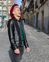 Young man smiling in the street on blurred background, happy concept