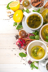 Various tea ball bombs. Assortment of different tea balls with dried tea, cups, lemon and mint, top view copy space. Trendy modern tea variety