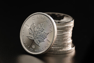 Gestapelte Silbermünzen - Ahornblatt - Kanadische Anlagemünze 1 Unze Feinsilber 9999 - Canada Maple Leaf FINE SILVER 9999 - Canadian Silver Maple Leaf Coin - obrazy, fototapety, plakaty