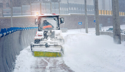 Tractor clear snow with rotating brush and snowplow from pedestrian zone on bridge, sidewalk snow...