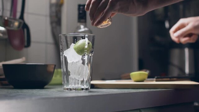 homemade of an alcoholic cocktail with ice, dark rum, lime and coca cola. adding alcohol shot to highball