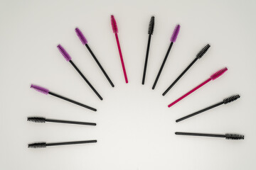 Makeup brushes, eyelash combs and eyebrows on white background with copy space