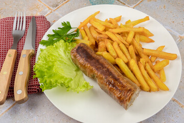 grilled andouillette with french fries and salad leaves