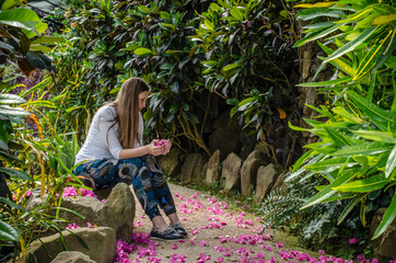 White Caucasian girl sitting at Botanic gardens, University of Lisbon - Jardim Botânico da...