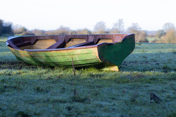 boat abandoned in grass field