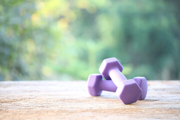 Purple dumbells on wooden table