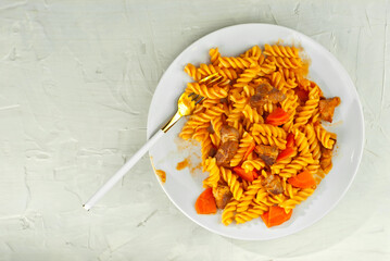 Pasta with meat in a white plate. Pasta on an old stone table. Copy space and free space for text near food.
