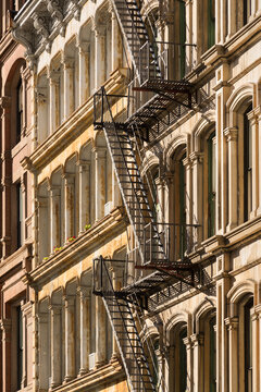 Typical Soho building facades with fire escapes located in the Soho Cast Iron Building Historic District. Manhattan, New York City
