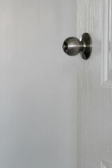 Door knob on white door and white wall background.