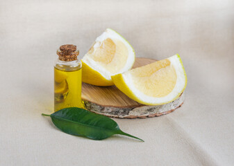 Citrus essential oil with pomelo on a wooden base. Natural healthy oil for spa treatments