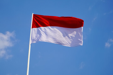 The single large red and white Indonesian flag flutters in the strong wind ahead of the 77th Independence Day of the Republic of Indonesia.