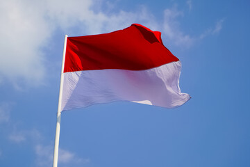 The single large red and white Indonesian flag flutters in the strong wind ahead of the 77th Independence Day of the Republic of Indonesia.