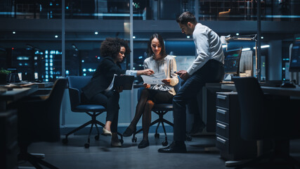 Diverse Team of Managers Working and Having Discussions in Big City Office in the Evening. Colleagues Talk, Discuss Business Opportunities, Evaluate Financial Reports, Plan Investment Strategy.