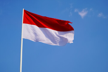 Naklejka na ściany i meble The single large red and white Indonesian flag flutters in the strong wind ahead of the 77th Independence Day of the Republic of Indonesia.