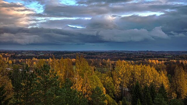 Time lapse on the cinematic landscape of the clouds moving above the forest background below on a natural look