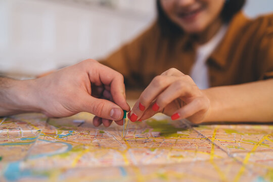 ?ouple pointing with notice board pins on city map