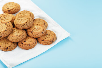 Oatmeal cookies on a blue background and a white napkin top view