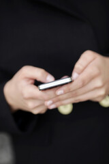 Hands of a woman texting on a mobile phone