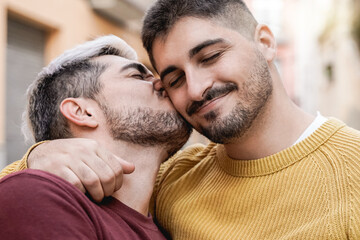 Gay male couple kissing outdoor in the city - LGBT love concept