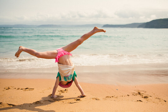 Girl cartwheeling on the beach