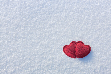 two red hearts on white winter snow, free space. Love concept and valentine's day background