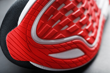 Running shoes with red soles on a black background.