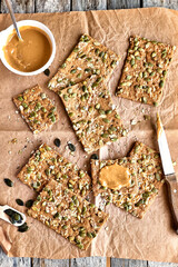 Crunchy crispbread and peanut butter on wooden table. Whole Grain crisp bread with pumpkin,...