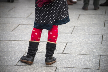 Closeup of red socks on legs of woman standing in the street