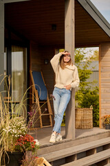 Woman watching standing on porch of house