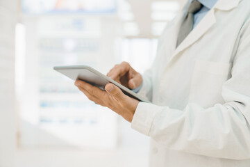 Cropped closeup shot of male pharmacist druggist chemist using digital tablet for checking online medicines remedy pills painkillers availability