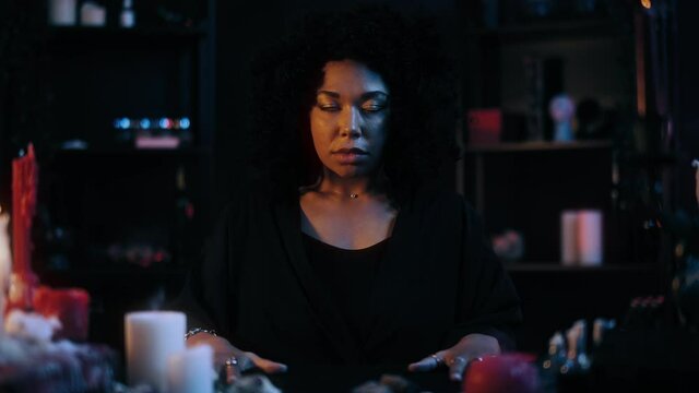 Scary possessed woman with dead eyes looking into camera, black voodoo magic. Medium, psychic, witch, oracle. Paranormal events