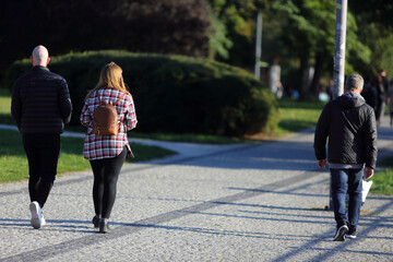 Kobieta z plecakiem spaceruje w parku we Wrocławiu.
