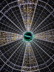 Circular neon abstraction glowing in the form of spider web on black background