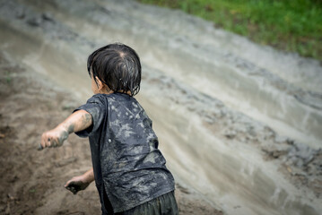 Asian happy child have activities on holidays. Son playing slider that made from mud. Happy...