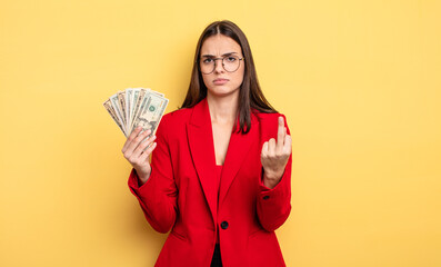 pretty woman feeling angry, annoyed, rebellious and aggressive. dollar banknotes concept