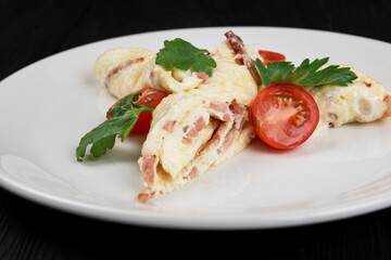 Omelet with Ham and Cheese and fresh vegetable on black wooden background