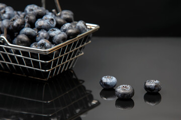 Fresh blueberries in a grocery basket on a background with a mirror image. vitamin food for health